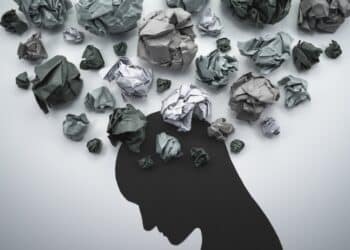 Silhouette of troubled person head. 
Concept image of anxiety and negative emotion. Waste paper and head silhouette.